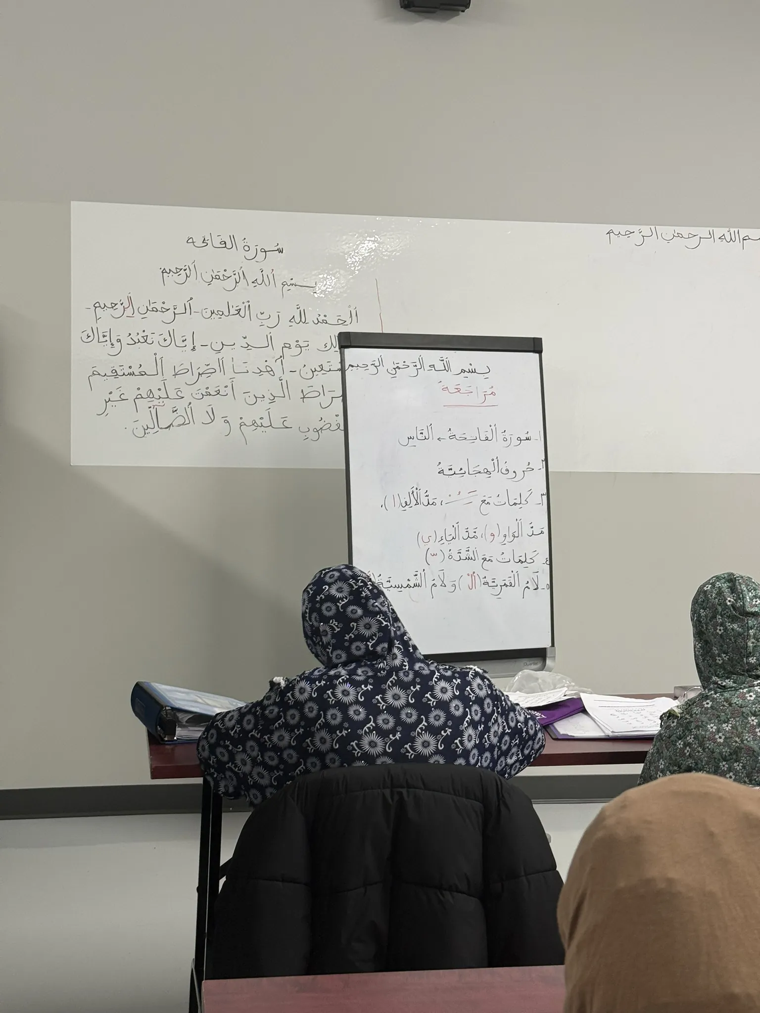 Une élève écrit au tableau en arabe.