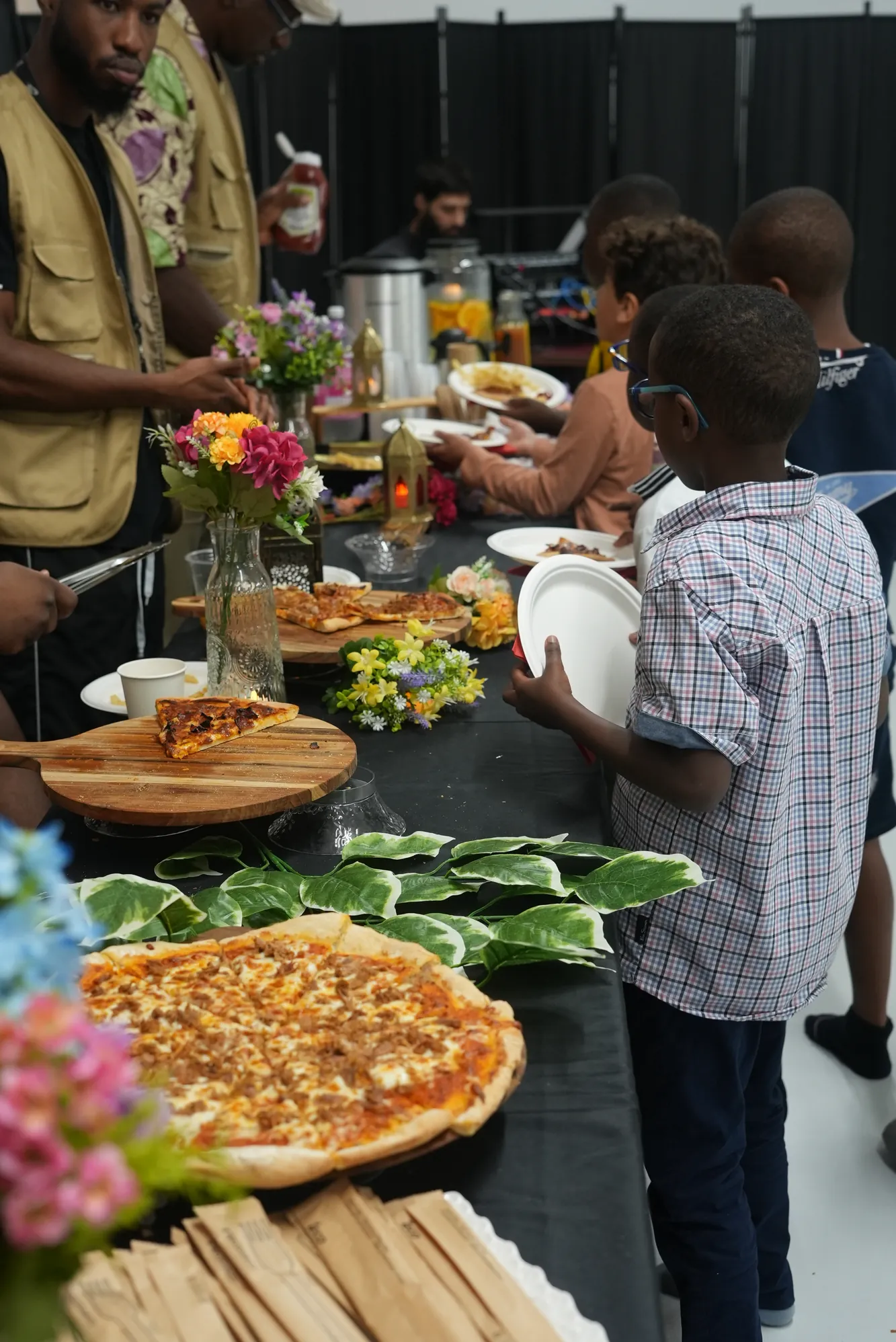 Un enfant se sert au buffet d’une fête communautaire.