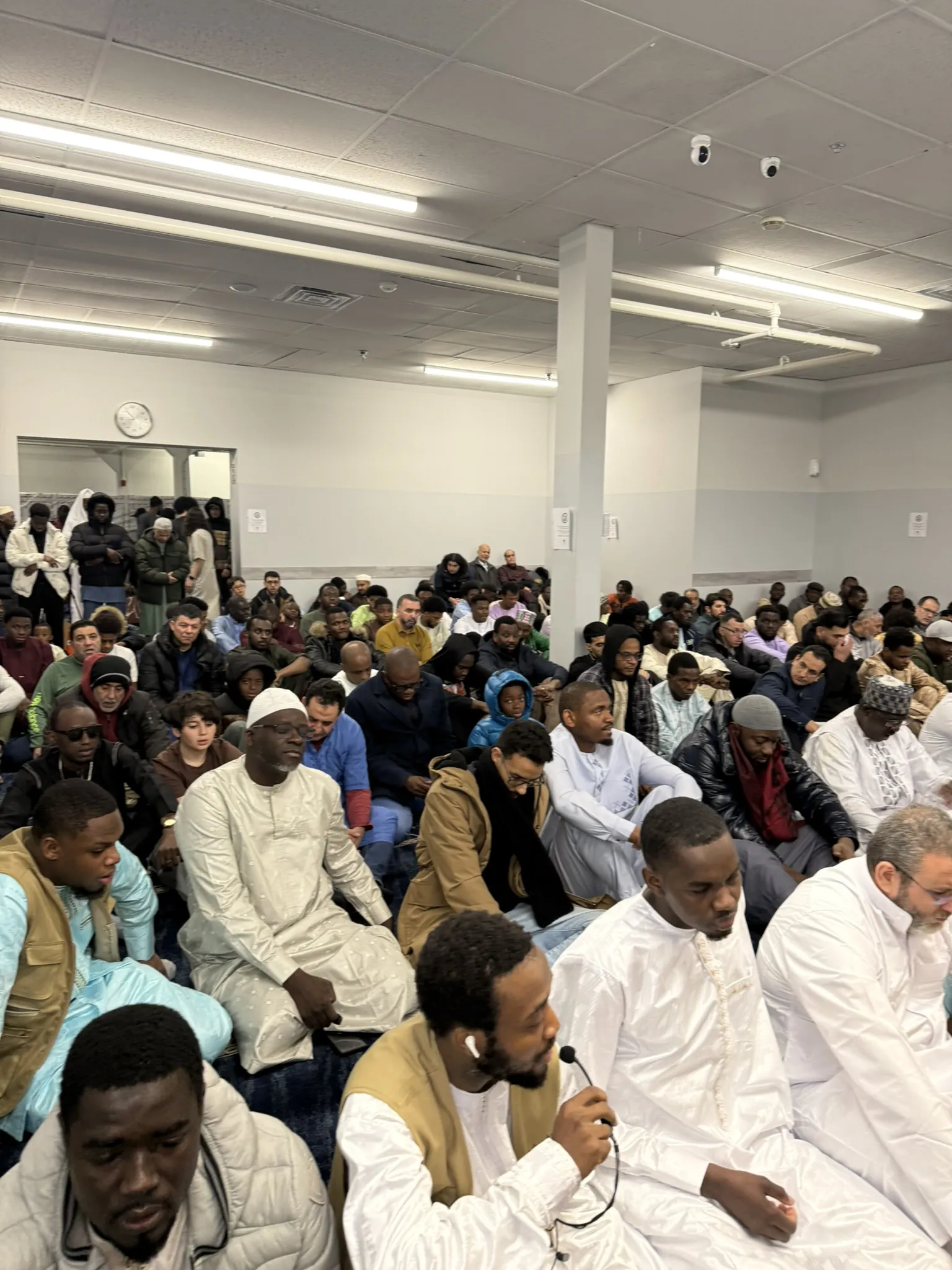 Une salle pleine de fidèles assis.