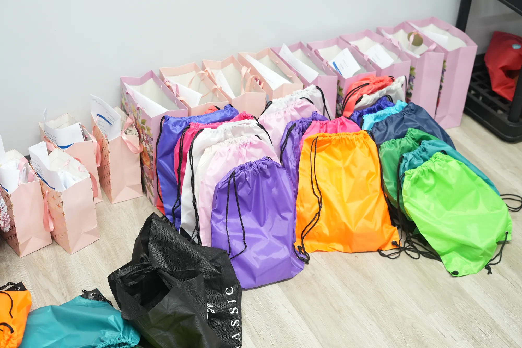 Des sacs à dos et des sacs-cadeaux alignés, prêts à être remis aux enfants.