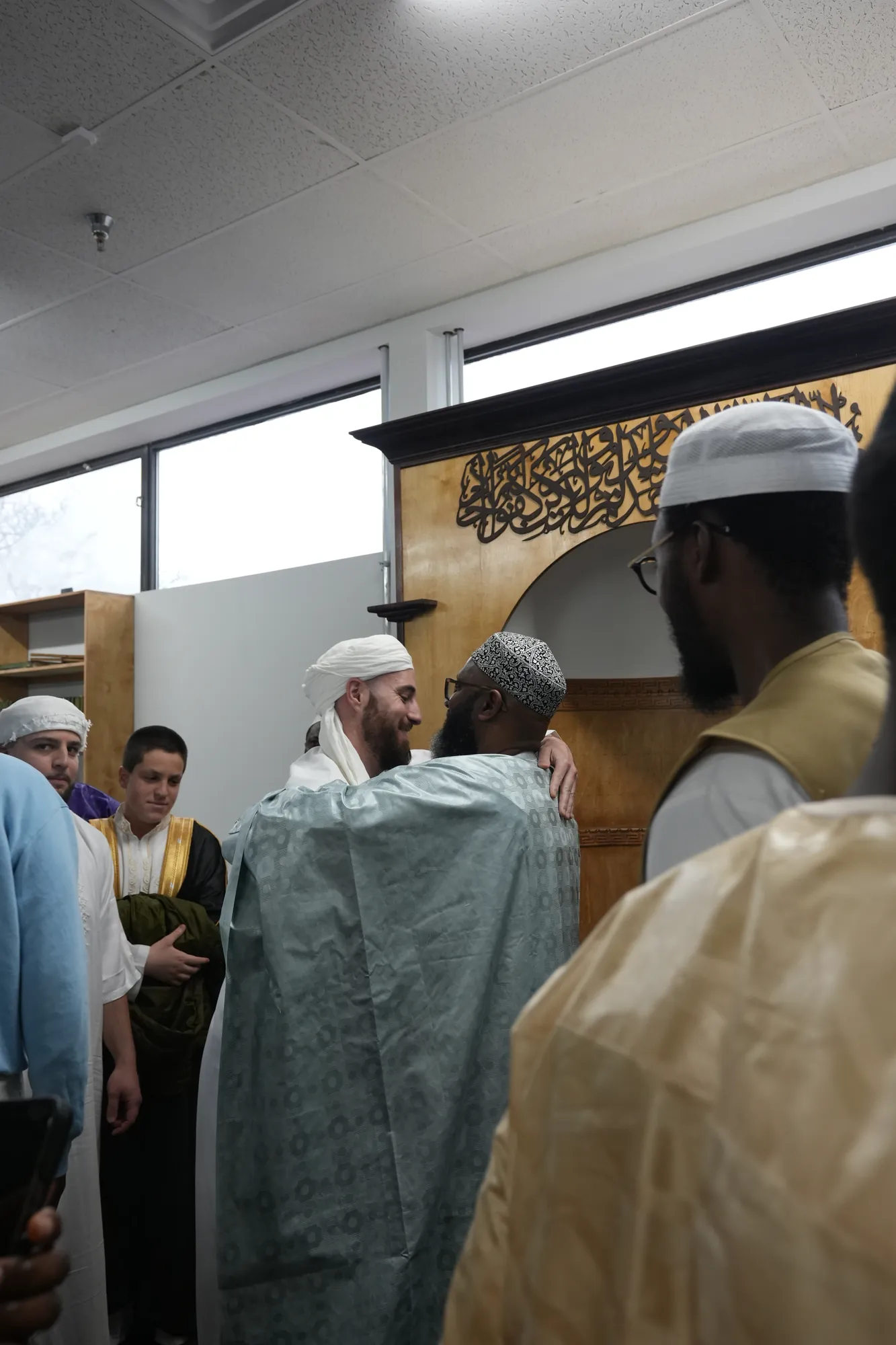 Des fidèles se saluent près du minbar.