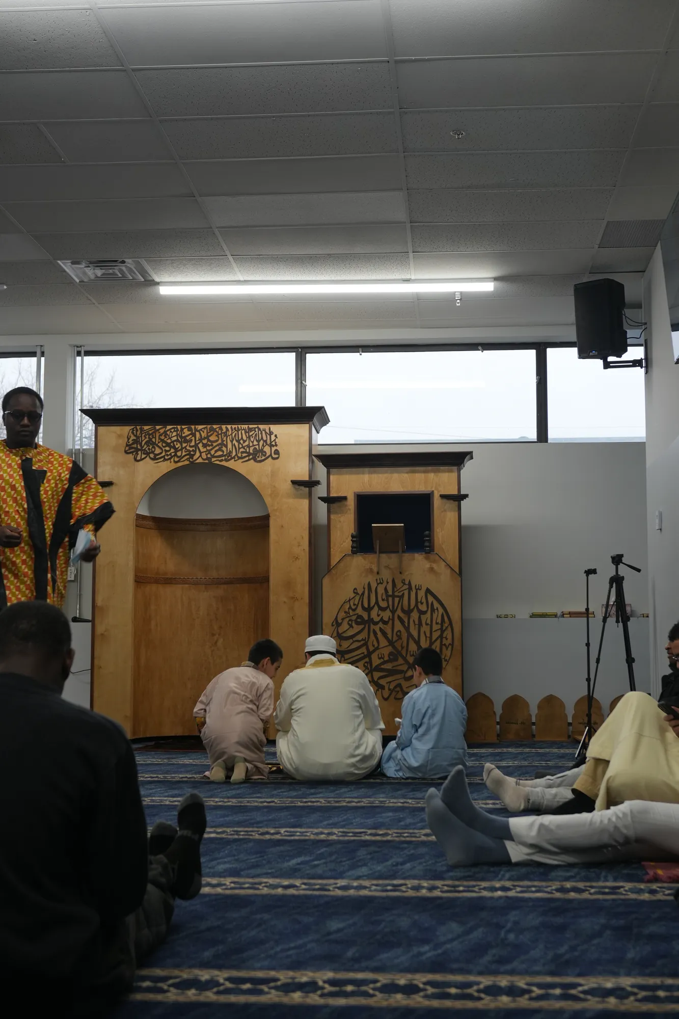 Des fidèles en prière devant le minbar de la mosquée Rahma.
